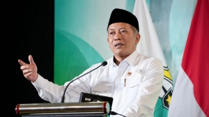 Seorang petugas sedang menata produk di salah satu gerai ritel modern di tengah isu pengaturan ekspansi di pedesaan.