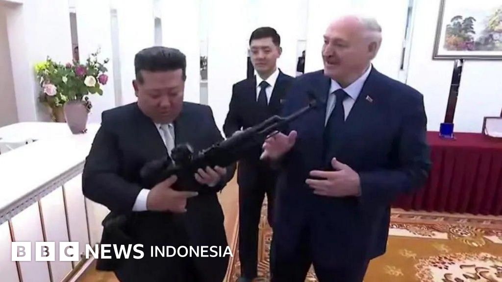 Presiden Belarusia Alexander Lukashenko (kiri) menyerahkan senapan kepada Pemimpin Korea Utara Kim Jong Un (kanan) saat kunjungan di Pyongyang. Pertukaran hadiah ini menandai penandatanganan perjanjian persahabatan antara kedua negara yang menghadapi sanksi internasional.