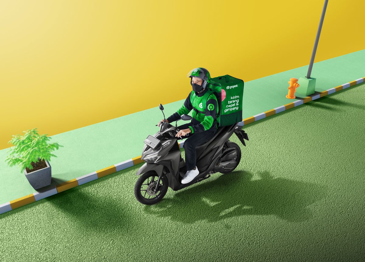 Mitra driver Gojek sedang beristirahat di sela-sela kesibukan melayani pelanggan, menunjukkan pentingnya program kesejahteraan dan jaring pengaman sosial yang transparan dari perusahaan.