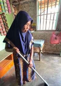 Nenek Mas Amah (78) setia menjaga warung kecilnya di Surakarta, menunjukkan semangat juang tak kenal lelah demi masa depan cucunya, Rendi.