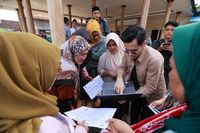 Petugas layanan informasi digitalisasi bansos membantu warga mengajukan sanggahan data penerima, demi memastikan keadilan dan transparansi program.