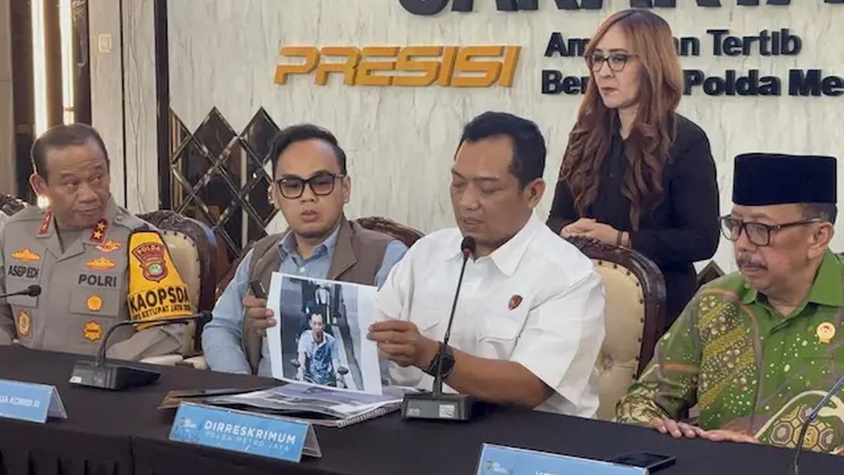 Seorang aktivis sedang memegang poster bertuliskan 'Adili Militer di Peradilan Umum' saat aksi unjuk rasa menuntut keadilan.