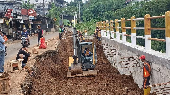 Tim pekerja sedang melakukan perbaikan intensif pada ruas jalan Cikampak-Gunung Bunder yang terdampak longsor, menunjukkan komitmen pemerintah daerah dalam pemulihan infrastruktur vital.