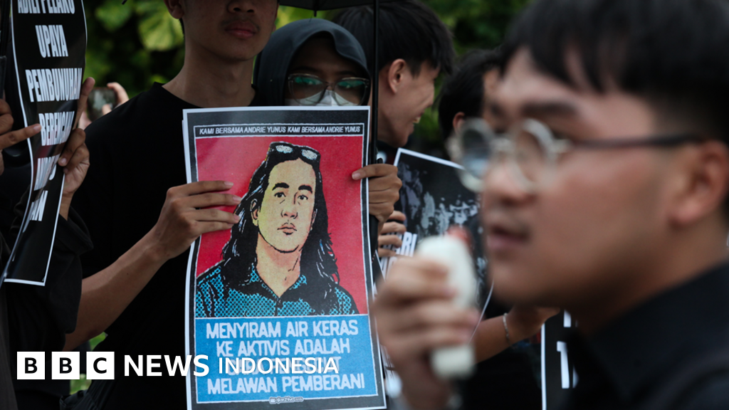 Seorang aktivis berdiri di depan demonstrasi menuntut pengungkapan kasus kekerasan, menyoroti ancaman terhadap kebebasan berpendapat di Indonesia.