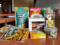 Seorang wirausaha perempuan sedang memeriksa produk UMKM. Banyak ibu rumah tangga berhasil mengubah modal terbatas menjadi bisnis sukses berkat pelatihan finansial.