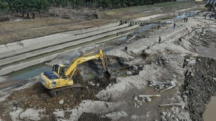 Petani mengawasi aliran air ke sawah setelah rehabilitasi sistem irigasi perpompaan di Aceh.