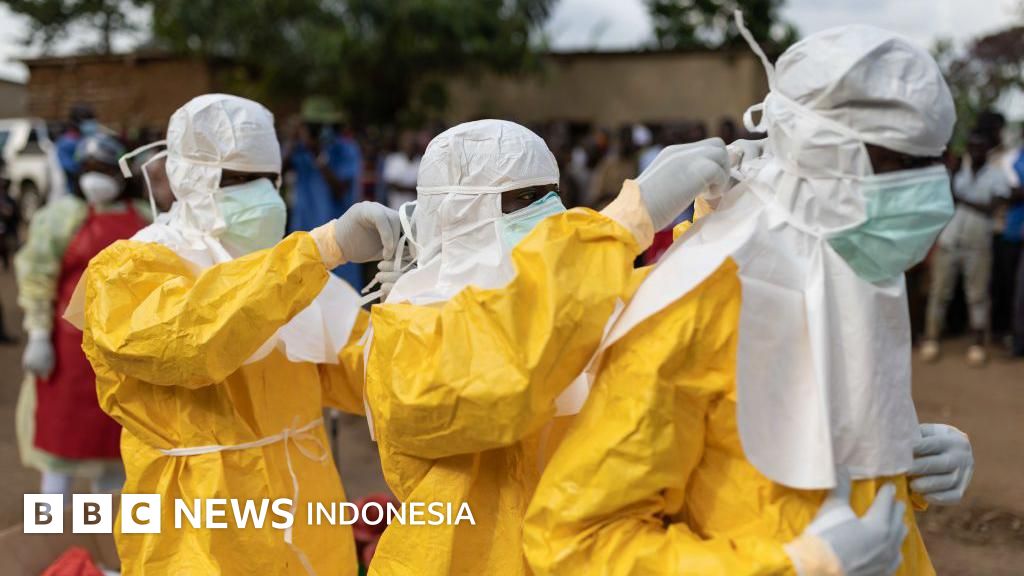 Tenaga medis dalam perlengkapan pelindung diri (APD) berinteraksi dengan masyarakat dalam upaya penanganan wabah Ebola di Republik Demokratik Kongo.
