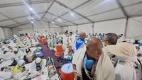 Jemaah haji berteduh di bawah payung dan tenda saat menjalankan ibadah di Makkah, Arab Saudi, di tengah cuaca panas ekstrem.
