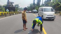 Petugas mengevakuasi pikap dan sepeda motor yang terlibat kecelakaan di Tanjakan Selarong, Puncak Bogor, yang mengakibatkan tiga orang terluka.