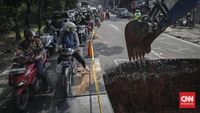 Pelat besi terpasang sebagai penanganan darurat jalan amblas di Jalan Raya Lenteng Agung, Jakarta Selatan, untuk menjaga keamanan pengguna jalan.
