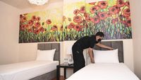 Seorang petugas hotel membersihkan kamar, salah satu pekerjaan vital yang pantas mendapat apresiasi dari tamu.