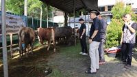 Anggota Polres Kepulauan Seribu berinteraksi dengan warga saat menyalurkan paket daging kurban, menunjukkan kedekatan dan komitmen kepedulian sosial di momen Idul Adha 1447 H.