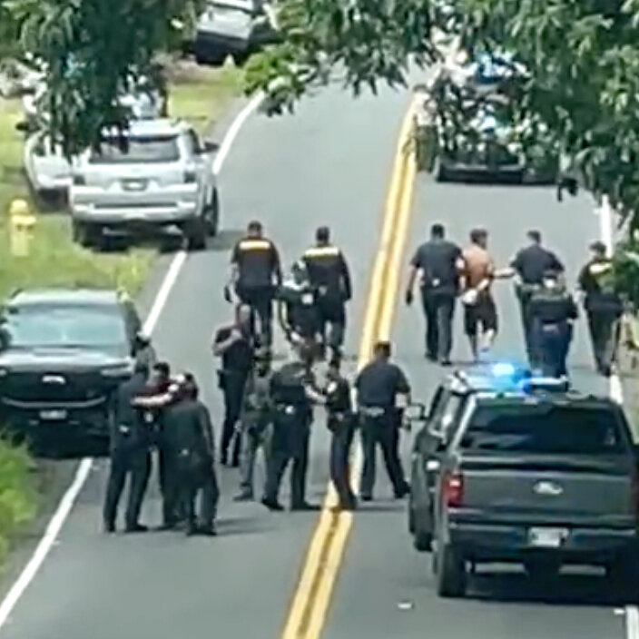 Petugas penegak hukum melakukan pencarian di medan terjal Pulau Besar Hawaii selama perburuan tersangka pembunuhan triple.