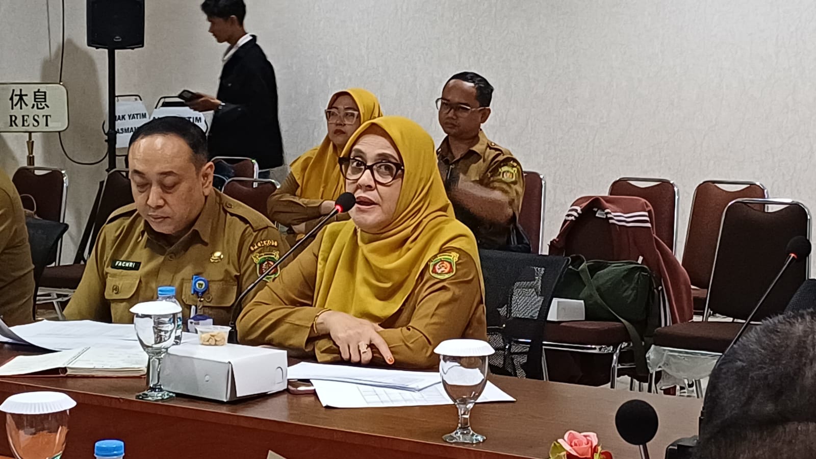Seorang pedagang di Pasar Pagi Samarinda tampak melayani pembeli di tengah penerangan seadanya, menyoroti tantangan operasional akibat belum tersedianya jaringan listrik langsung ke lapak.