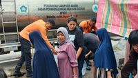 Petugas BPBD Kabupaten Bogor mendistribusikan bantuan air bersih menggunakan truk tangki kepada warga terdampak kekeringan di Kampung Parakan Muncang, Nanggung. Bantuan ini menjadi harapan di tengah krisis air akut akibat musim kemarau.