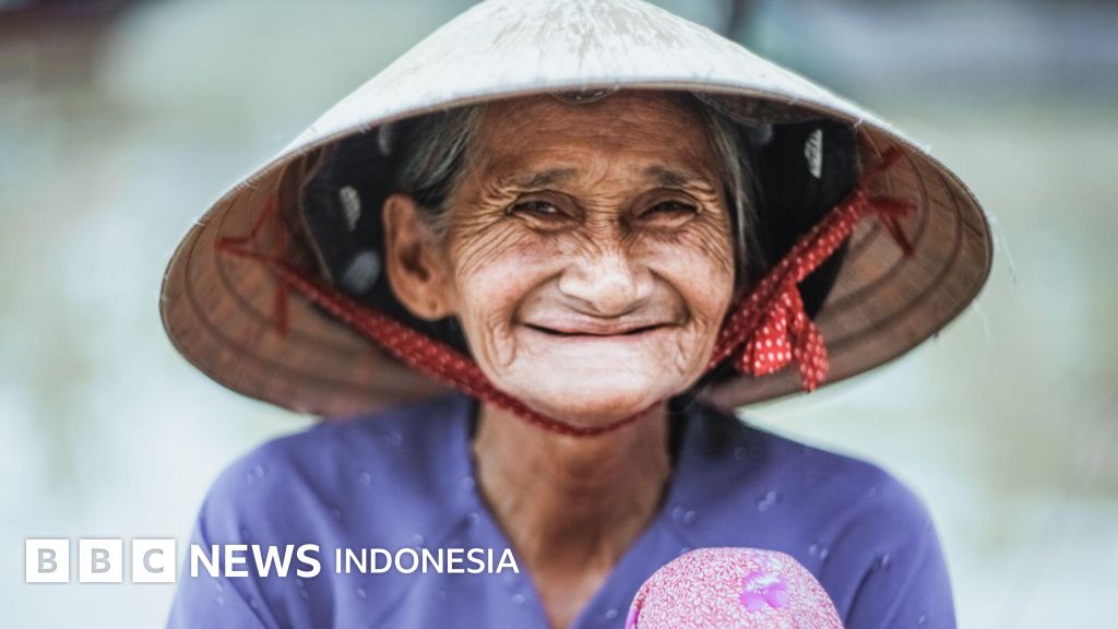 Seorang wanita tersenyum ceria, mencerminkan salah satu aspek dari tren global di mana perempuan cenderung memiliki harapan hidup yang lebih panjang dibandingkan laki-laki.