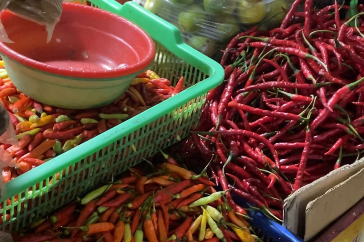 Pedagang menunjukkan bawang merah dan cabai rawit yang mengalami kenaikan harga signifikan di pasar tradisional.
