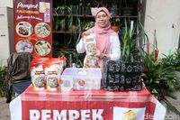 Nyayu Maryati, pendiri Pempek Rafi 81, menunjukkan salah satu produk andalannya. Keberaniannya beradaptasi dengan selera pasar Jakarta dan memanfaatkan pelatihan UMKM menjadi kunci sukses brand kuliner ini.