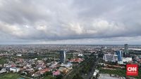 Ilustrasi warga Surabaya mengenakan pakaian hangat untuk menghadapi suhu dingin malam hari akibat fenomena 'Bediding Landa' yang menandai awal musim kemarau.