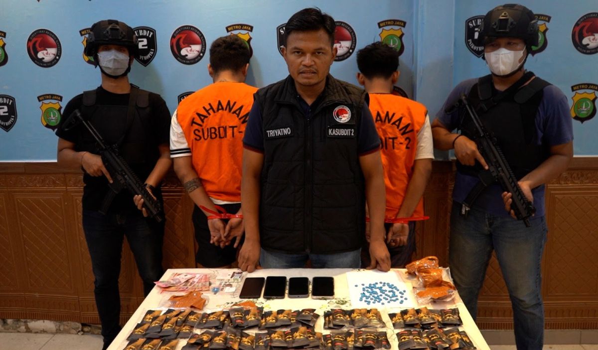 Petugas Direktorat Reserse Narkoba Polda Metro Jaya menunjukkan barang bukti narkoba jenis etomidate dan ekstasi yang disamarkan dalam karung beras basmati dari jaringan Malaysia di Jakarta Pusat.