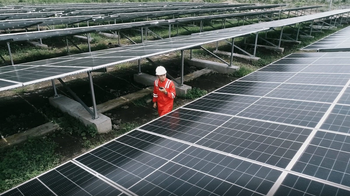 Panel surya di tengah lanskap hijau menunjukkan komitmen Indonesia dan potensi energi bersih di pasar global.