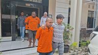 Petugas kepolisian menggiring tersangka kasus pengeroyokan di kantor polisi. (Ilustrasi)