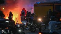 Petugas polisi anti huru hara berhadapan dengan kerumunan suporter Paris Saint-Germain (PSG) yang merayakan kemenangan gelar Liga Prancis di jalanan Paris, di tengah kerusuhan massal.