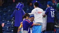 Suporter timnas Jepang membersihkan tribun stadion setelah pertandingan usai. Aksi ini telah menjadi tradisi yang diakui dunia dan terus menginspirasi.