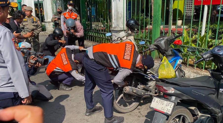 Petugas Dinas Perhubungan DKI Jakarta melakukan penertiban kendaraan yang parkir sembarangan di salah satu titik rawan kemacetan.