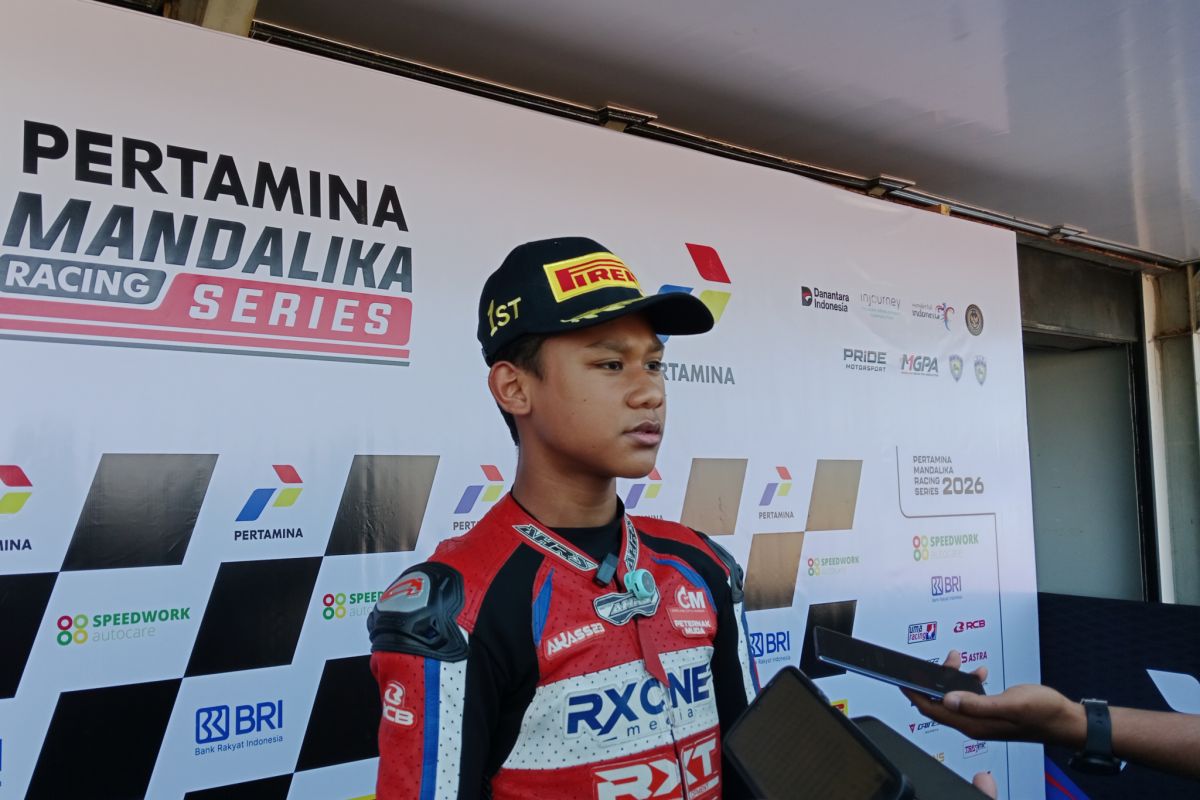 Pembalap Muhammad Gibran (tengah) berdiri di podium tertinggi setelah memenangi race pertama kelas IJTC 150cc U-15 pada Kejuaraan Nasional Mandalika Racing Series (MRS) 2026 di Sirkuit Internasional Mandalika.