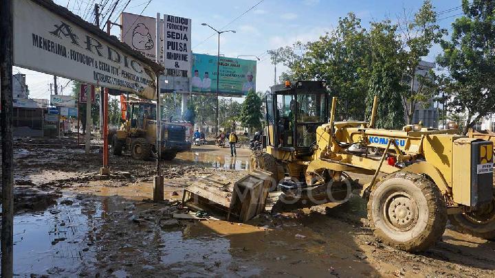 Petugas meninjau kondisi infrastruktur jalan yang rusak parah pascabanjir di wilayah Aceh Tamiang, menunjukkan urgensi alokasi dana pemulihan dan rekonstruksi.