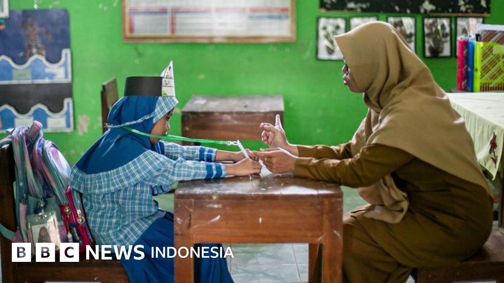 Petugas kepolisian berjaga di area SDN Serengseng Sawah setelah adanya laporan ancaman bom yang membatalkan MPLS.