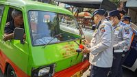 Petugas Dinas Perhubungan sedang memeriksa dokumen dan kondisi fisik angkot yang terjaring razia di salah satu jalan utama, dalam upaya penertiban kendaraan tidak laik jalan.