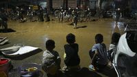 Warga Desa Gantang, Guangxi, menyusuri puing-puing rumah mereka yang hancur, dikelilingi lumpur tebal pasca jebolnya waduk yang menewaskan 39 jiwa. Upaya pembersihan dan pencarian korban masih terus berlanjut di tengah kesulitan.