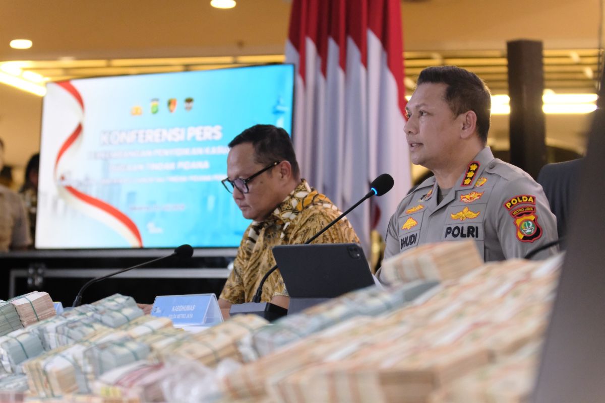 Petugas kepolisian menunjukkan tumpukan uang tunai yang ditemukan dalam sebuah penggeledahan terkait kasus dugaan korupsi dan pencucian uang. (Foto Ilustrasi)