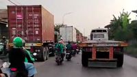 Kemacetan parah yang didominasi truk kontainer di Jalan Cakung-Cilincing, Jakarta Utara, membuat pengendara motor frustrasi dan 'terpanggang' di tengah padatnya lalu lintas. Desakan untuk pemisahan jalur khusus kontainer terus menguat.