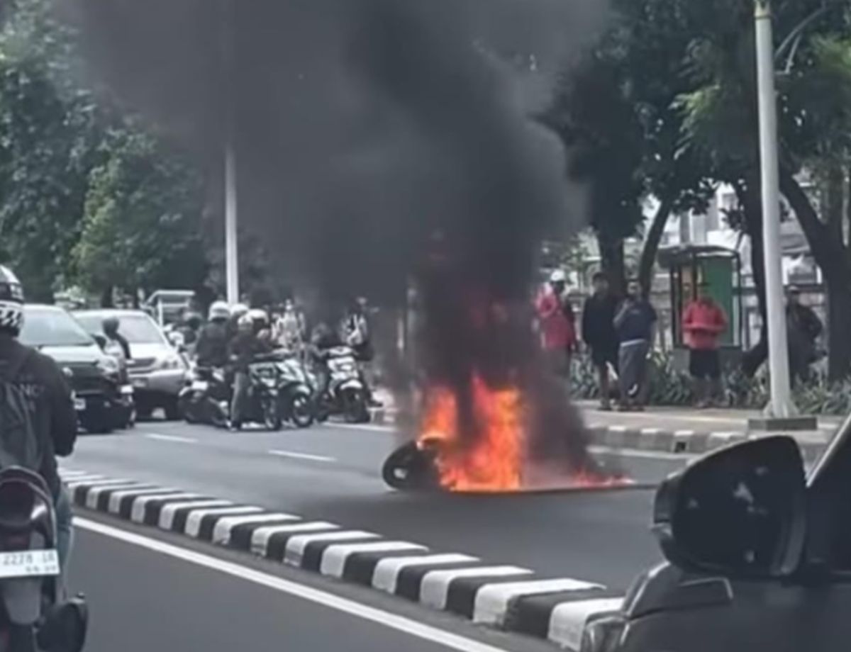 Sepeda motor yang hangus terbakar di tengah Jalan Raya Pasar Minggu, Jakarta Selatan, setelah menghindari pengereman mendadak, Minggu (12/7/2026).