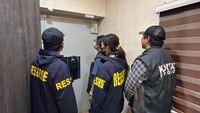 Petugas kepolisian saat melakukan penyitaan barang bukti dari lokasi penggeledahan terkait kasus korupsi.