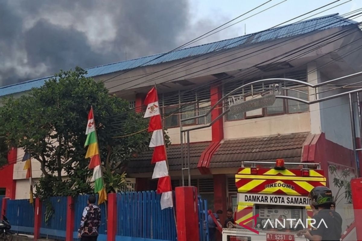 Petugas Disdamkar Samarinda bersama relawan bahu-membahu memadamkan api yang membakar sebagian bangunan SDN 001 Samarinda.
