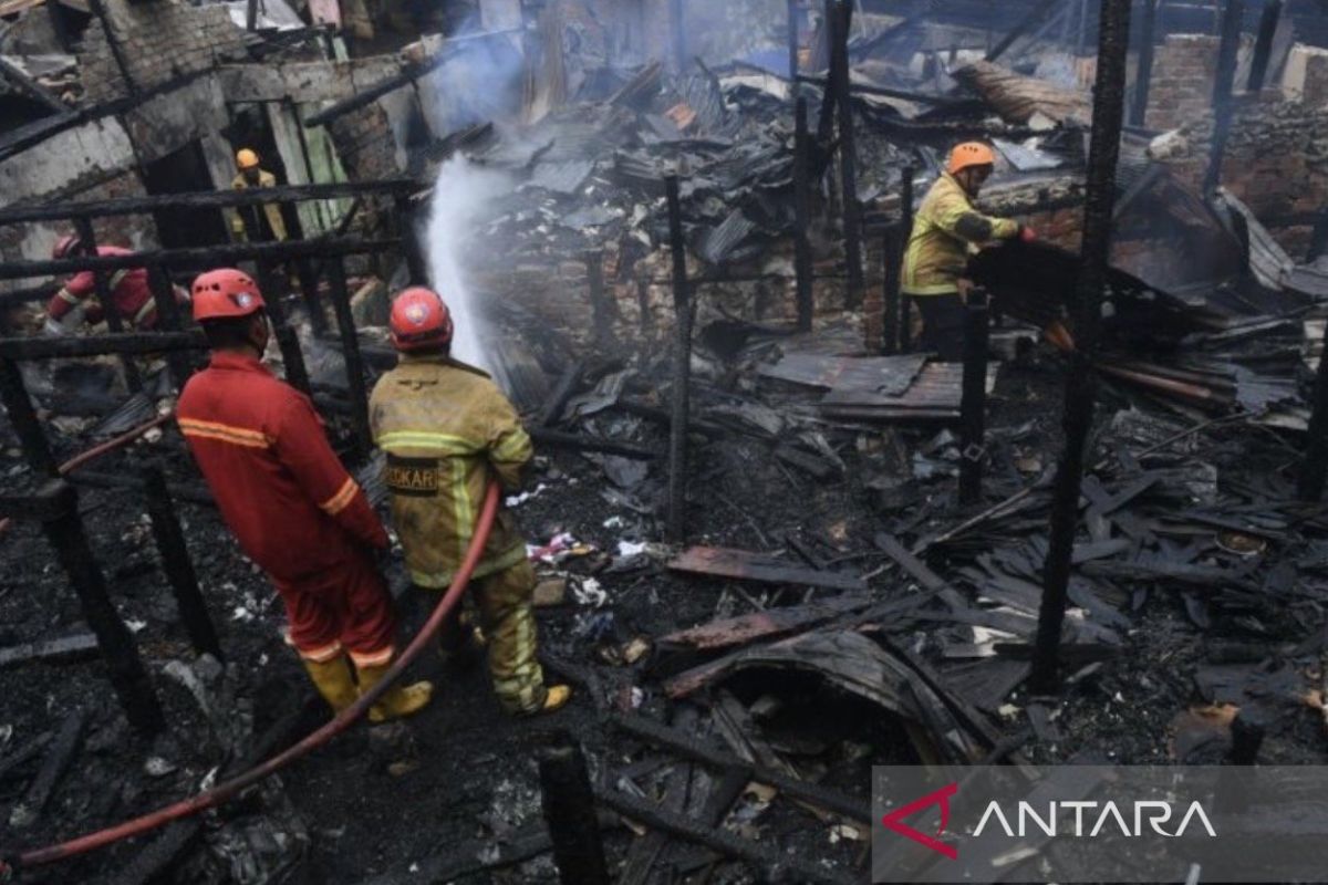 Petugas pemadam kebakaran berjuang memadamkan api yang melalap belasan rumah di kawasan Dahor II Balikpapan Barat pada Kamis pagi.