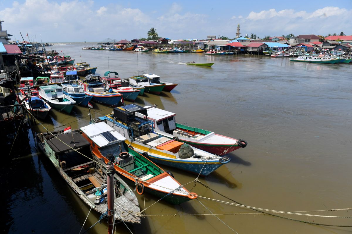 Seorang nelayan di Balikpapan sedang memeriksa jaringnya, tidak dapat melaut akibat peringatan BMKG tentang cuaca ekstrem dan gelombang tinggi.