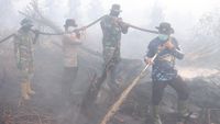 Personel gabungan dari TNI, Polri, BPBD, dan Manggala Agni bergotong royong memadamkan dan mendinginkan lahan gambut yang terbakar di Kampar, Riau.