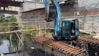 Warga Tegal Alur bergotong royong membangun jembatan bambu di atas Kali Semongol, solusi darurat yang kini dijanjikan akan diganti dengan jembatan beton permanen oleh Pemprov DKI Jakarta.