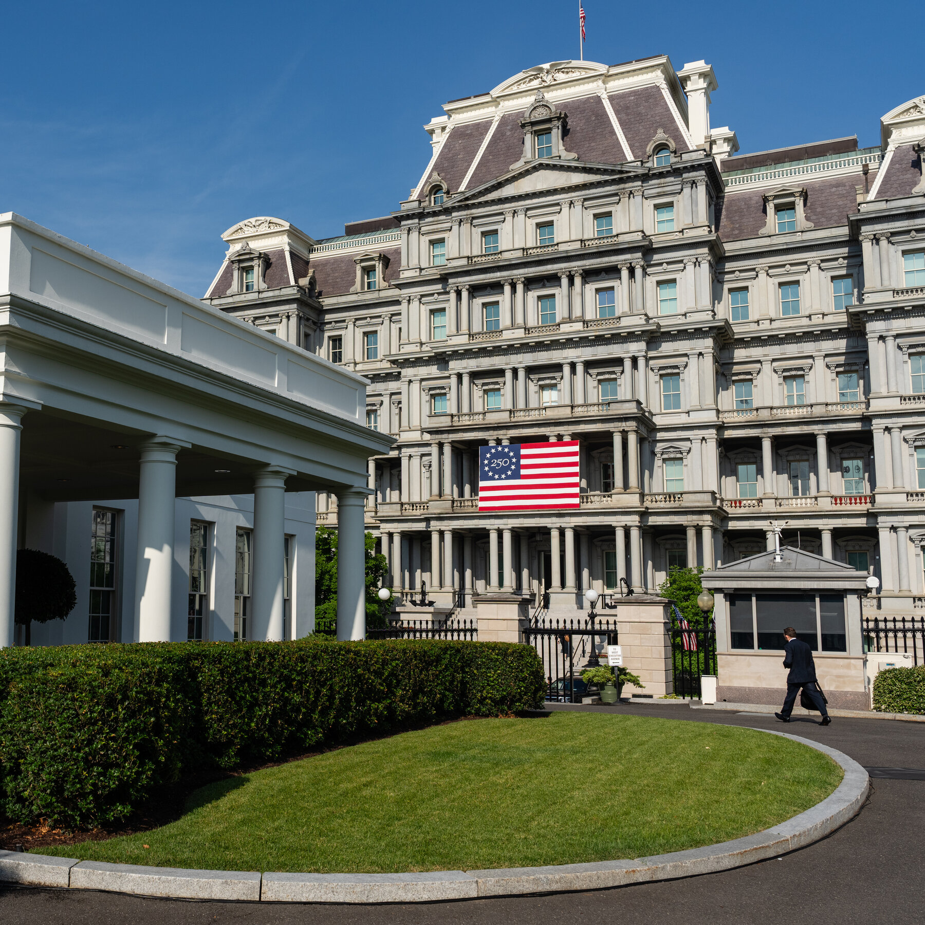 Seorang pengunjung Gedung Putih melewati area dekat fasilitas rekreasi di dalam kompleks Gedung Putih, Washington D.C. Renovasi lintasan bowling senilai Rp 3,9 miliar memicu pertanyaan tentang prioritas anggaran.