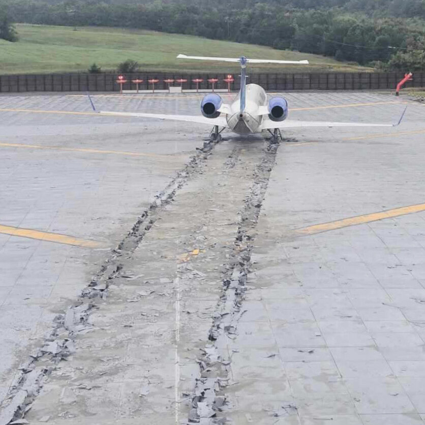 Pesawat komersial mendarat di landasan pacu yang dilengkapi dengan Engineered Material Arresting System (EMAS) sebagai fitur keselamatan tambahan di ujung landasan.