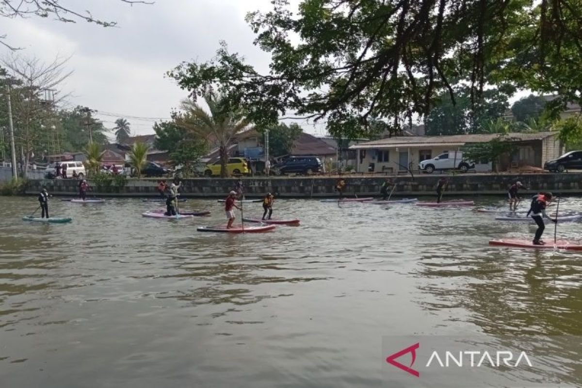 Peserta lomba antusias memungut sampah di sungai melalui kegiatan olahraga air, menggabungkan rekreasi dengan misi pelestarian lingkungan.