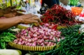 Seorang pedagang merapikan tumpukan cabai merah keriting di salah satu pasar tradisional. Fluktuasi harga komoditas pangan seperti cabai dan bawang merah kerap menjadi perhatian utama stabilitas ekonomi nasional.