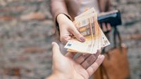 Ilustrasi: Uang rupiah berserakan, melambangkan kerugian finansial akibat penipuan online yang marak terjadi.