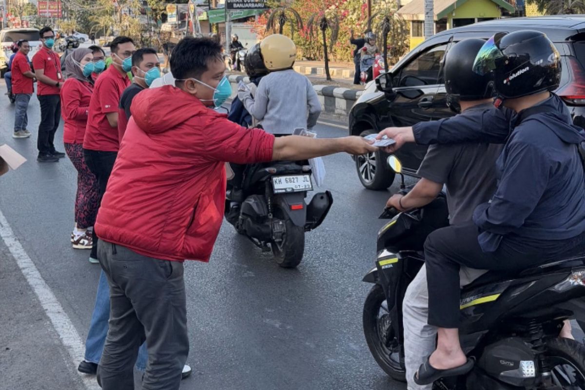 Petugas kesehatan Dinas Kesehatan Kota Samarinda memberikan edukasi dan membagikan masker kepada warga sebagai upaya preventif menghadapi ancaman kabut asap karhutla dan lonjakan kasus ISPA.