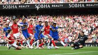 Skuad Arsenal merayakan gol, menunjukkan dominasi mereka di awal musim Liga Primer, sementara pandangan Xabi Alonso mengingatkan akan ketatnya persaingan.